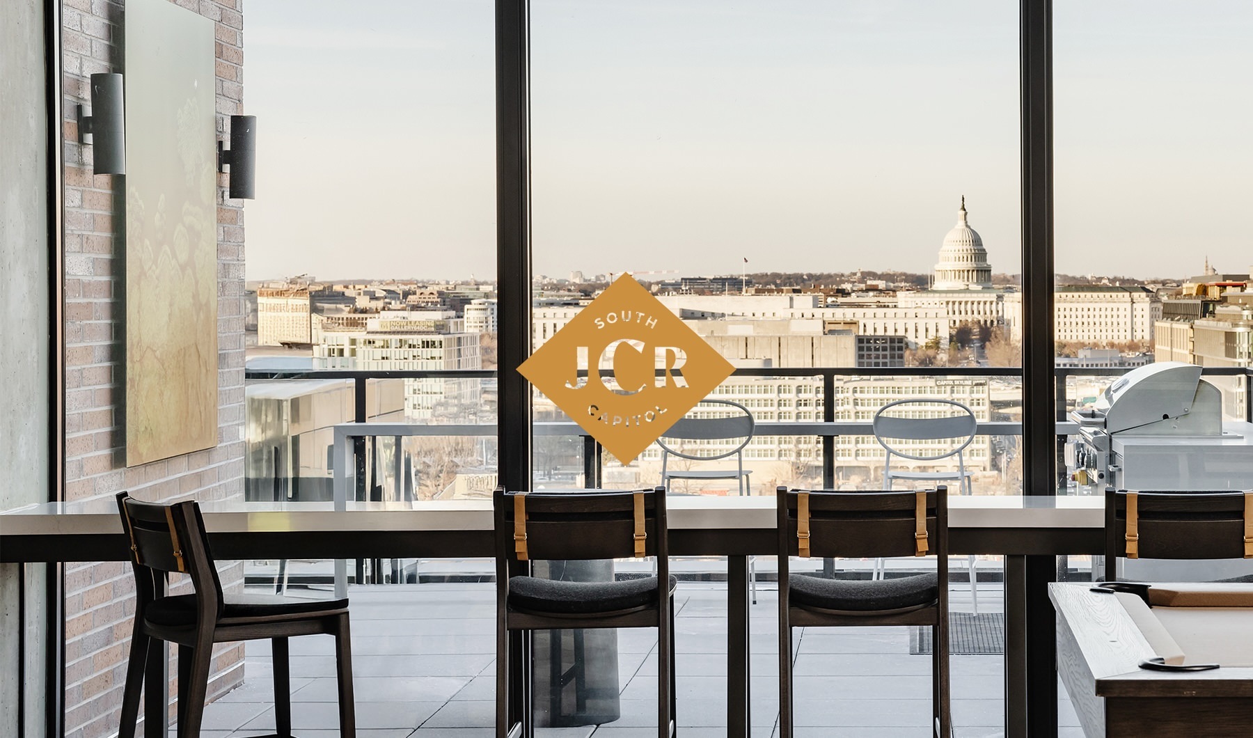 Apartments Near Capitol Hill lounge with floor-to-ceiling windows overlooking Capitol building in distance